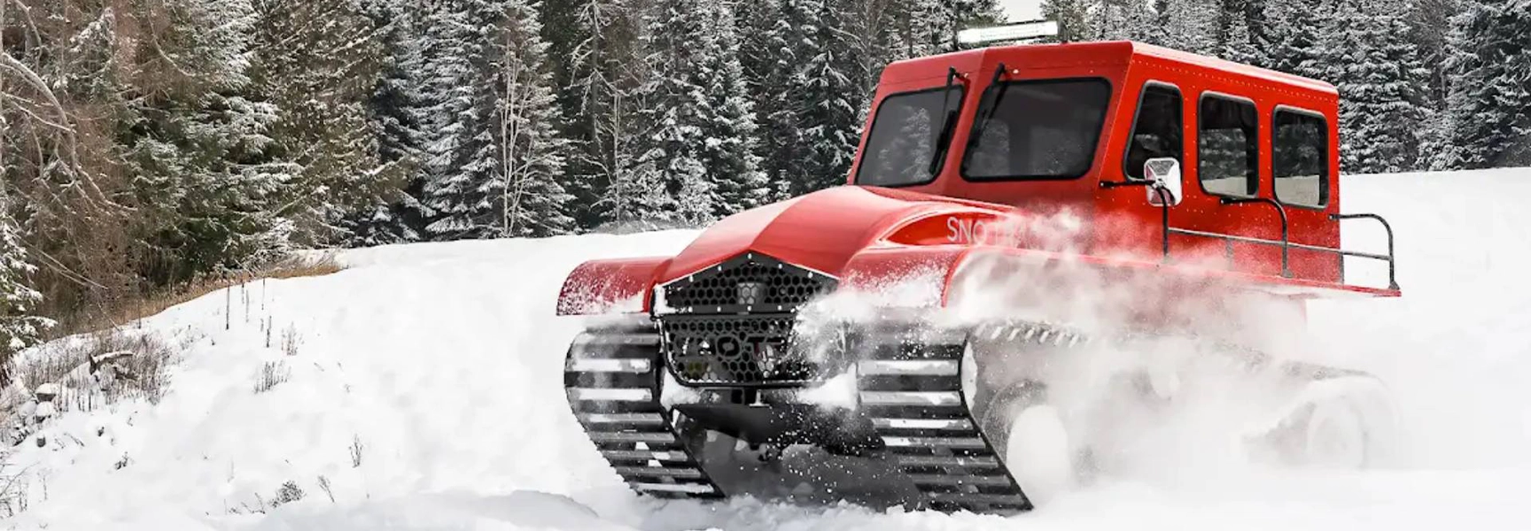 Red tracked snowcat vehicle clearing snow in winter environment