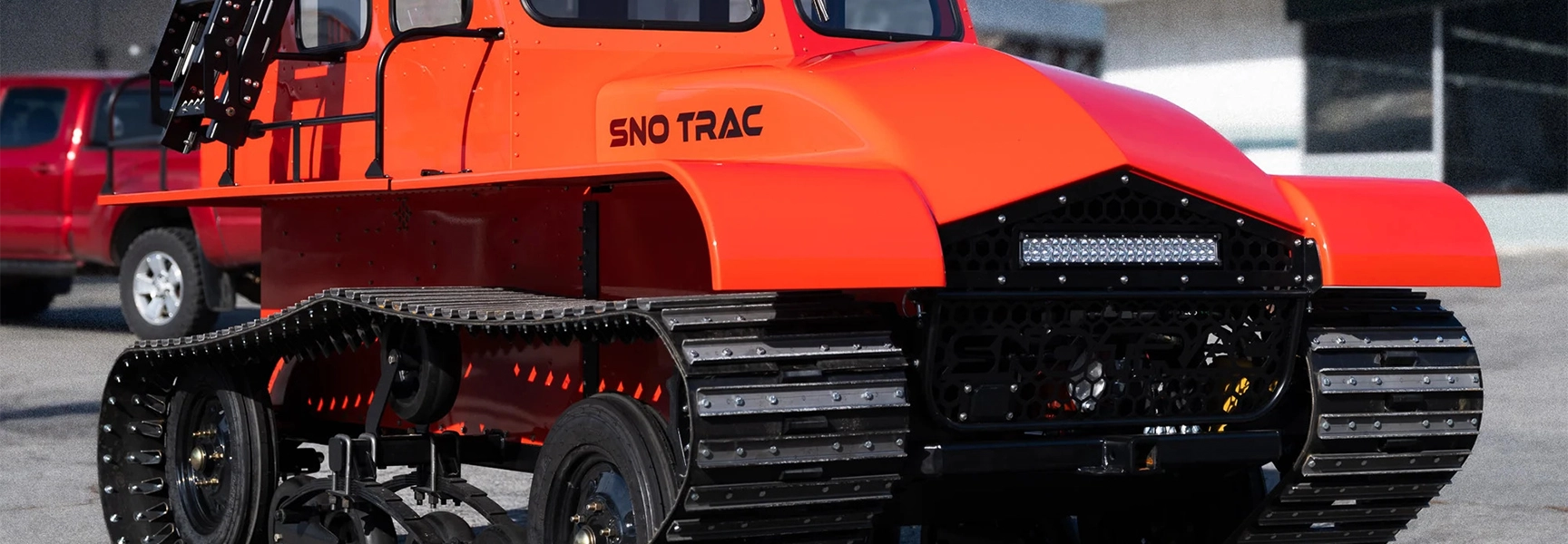Snowcat rescue vehicle driving through snow-covered forest terrain